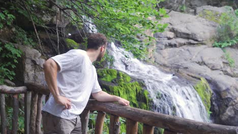 Tourist-man-is-resting-at-the-waterfall.